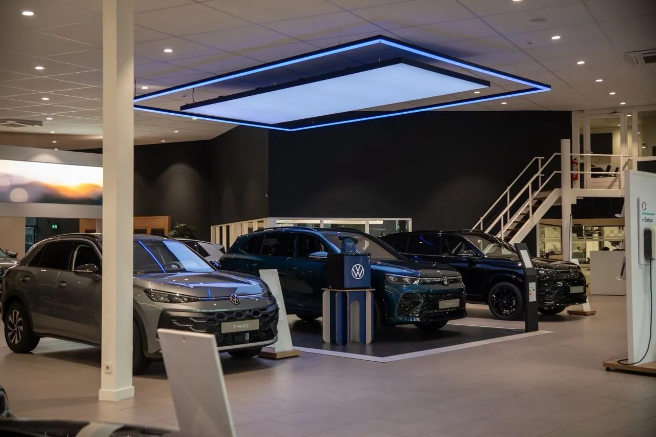 Autoshowroom met een groot verlicht plafondelement boven de auto's