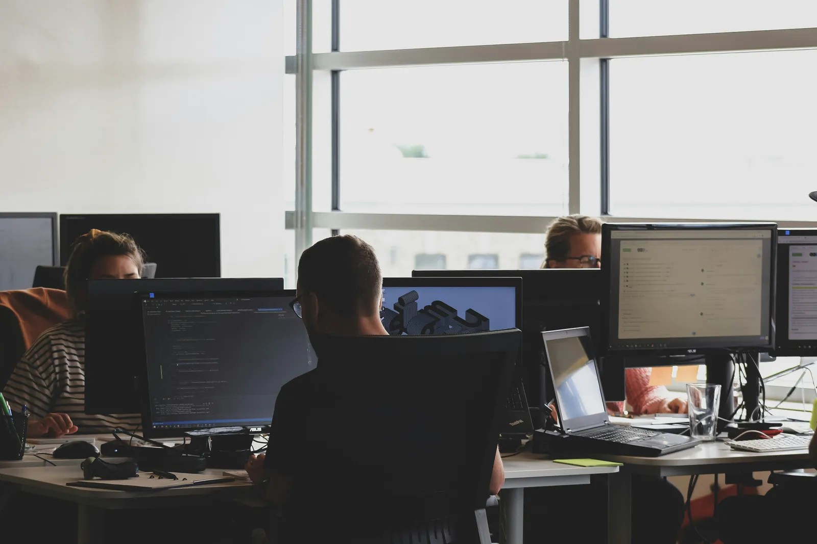 Collega's aan het werk achter beeldschermen bij een softwarebedrijf